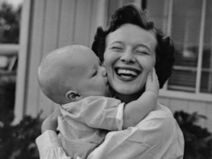A woman laughs as a baby hugs and kisses her, circa 1945. (Photo by Pictorial Parade/Archive Photos/Getty Images)