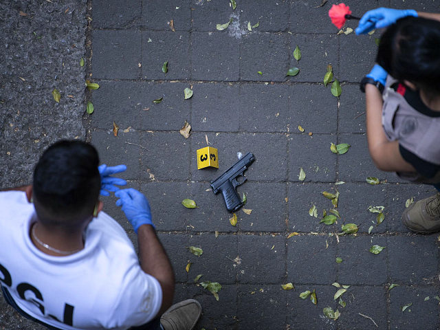 Mexican forensic experts observe a gun used on an assault at La Condesa neighborhood, in Mexico City, on may 6, 2019. - According to the authorities, three assailants tried to steal the vehicle of Mexican journalist Hector de Mauleon and his bodyguard repelled the assault. (Photo by PEDRO PARDO / …