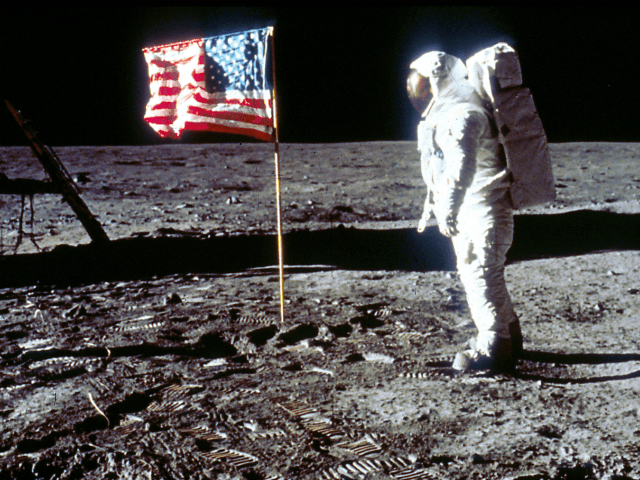 Astronaut Edwin "Buzz" Aldrin poses next to the U.S. flag …