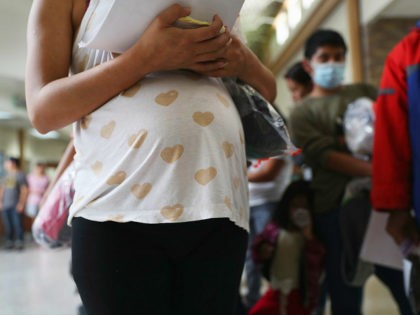 MCALLEN, TX - AUGUST 15: A pregnant Honduran immigrant stands in line with fellow immigran