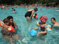Louis (L), 2, and his sister Clara, 4, cool off in the shallow pool with their parents at the Freibad Kiebitzberge outdoor public pool on July 27, 2013 in Berlin, Germany. Central Europe is currently experiencing a heat wave that is predicted to bring temperatures to 40 degrees Celsius by …