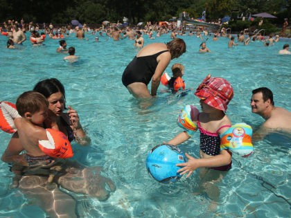 Louis (L), 2, and his sister Clara, 4, cool off in the shallow pool with their parents at the Freibad Kiebitzberge outdoor public pool on July 27, 2013 in Berlin, Germany. Central Europe is currently experiencing a heat wave that is predicted to bring temperatures to 40 degrees Celsius by …