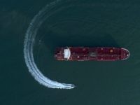 In this Sunday, July 21, 2019 photo, an aerial view shows a speedboat of Iran's Revolutionary Guard moving around the British-flagged oil tanker Stena Impero which was seized in the Strait of Hormuz on Friday by the Guard, in the Iranian port of Bandar Abbas. Global stock markets were subdued …