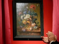 The "Vase of Flowers" painting by Jan van Huysum, is unveiled during a ceremony at the Pitti Palace, part of the Uffizi Galleries, in Florence, Italy, Friday, July 19, 2019. Germany returned the Dutch still-life after it was stolen by Nazi troops during WWII. (AP Photo/Gregorio Borgia)