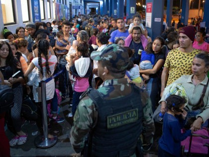 Venezuelan migrants wait to get a refugee application at the Peruvian border post at the b