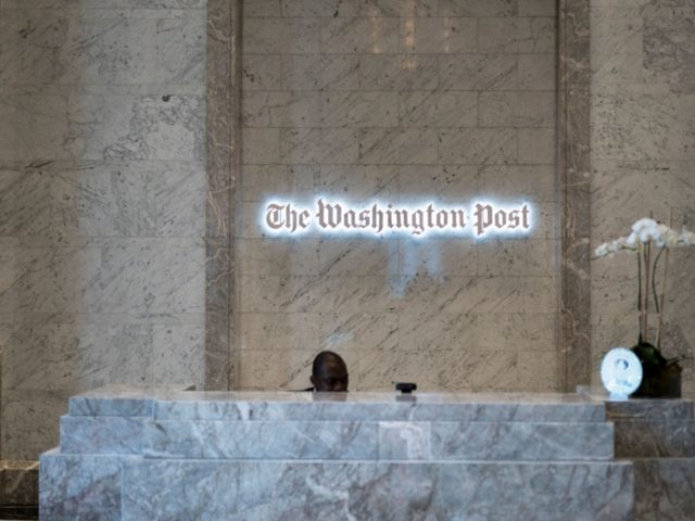 A man walks into the Washington Post's new building March 3, 2016 in Washington, DC. A gua