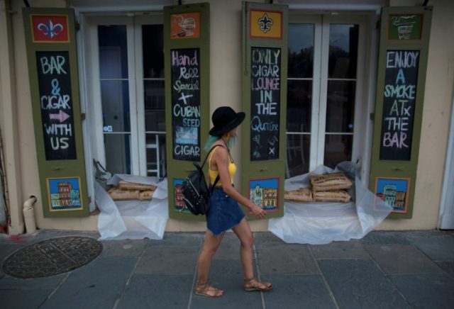 A woman walks past a cigar lounge and bar protected by sand bags in the French Quarter of New Orleans, in preparation for tropical storm Barry Braced for Barry: New Orleans girds for 'extreme' storm