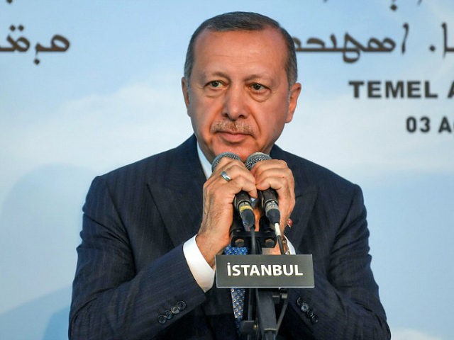 Turkish President Recep Tayyip Erdogan holds the microphones as he delivers a speech during the first stone ceremony of Turkey's first church in the modern history of the modern Republic in Istanbul's Yesilkoy district, on August 3, 2019. - President Recep Tayyip Erdogan on August 3 laid a stone for …