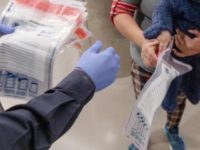 A CBP officer inspects immigration documents at a port of entry from Mexico. (File Photo: U.S. Customs and Border Protection/Mani Albrecht)