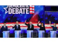 Democratic presidential candidates raise their hands at last week's debate when asked if their health care plans would cover undocumented immigrants. Photo: Saul Loeb/AFP/Getty Images