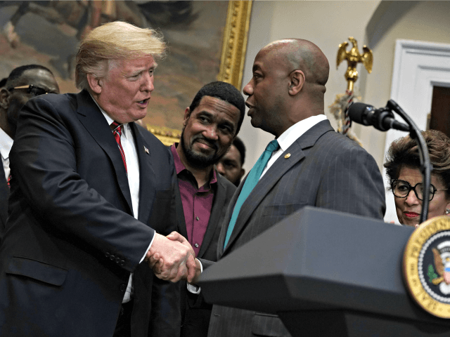 WASHINGTON, DC - DECEMBER 12: US President Donald Trump (L) shakes hands with Senator Tim Scott (R-L) (L) during a signing event for an executive order establishing the White House Council on Opportunity and Revitalization on Dec. 12.  2018 in the Roosevelt Room of the White House in Washington, DC.  The creation of the council will oversee the Opportunity Districts program and be chaired by Secretary of Housing and Urban Development Ben Carson.  (Photo by Alex Wong/Getty Images)
