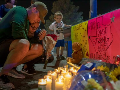 Rene Aguilar and Jackie Flores pray at a makeshift memorial for the victims of Saturday's mass shooting at a shopping complex in El Paso, Texas, Sunday, Aug. 4, 2019. (AP Photo/Andres Leighton)