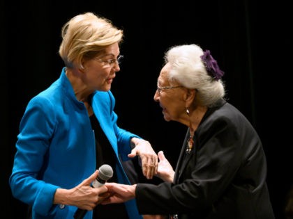 Democratic presidential candidate Sen. Elizabeth Warren (D-MA) (L) is escorted on stage by Marcella LeBeau at the Frank LaMere Native American Presidential Forum on August 19, 2019 in Sioux City, Iowa. Warren was introduced by Rep. Deb Haaland (D-NM) who she has co-sponsored legislation with to help the Native American …
