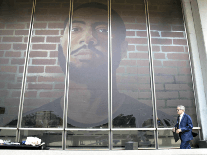 Philadelphia DA Larry Krasner walks by a self-portrait made by a formerly incarcerated art