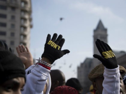 Lesley McSpadden (C), mother of Ferguson shooting victim Michael Brown, holds up her hands with gloves that say "Don't Shoot" during the "Justice For All" march in Washington, DC, December 13, 2014. Thousands of people descended on Washington to demand justice Saturday for black men who have died at the …