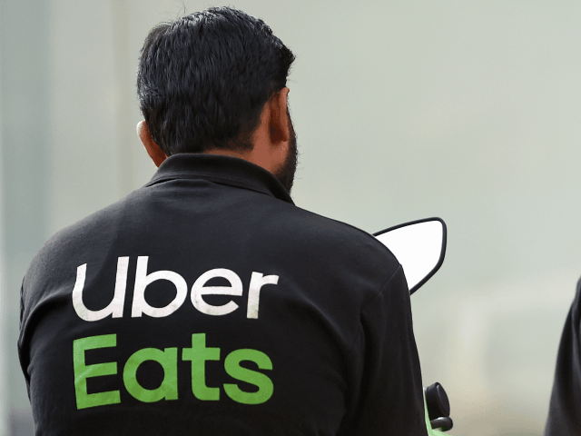 In this photo taken on February 6, 2019, Indian delivery men working with the food delivery apps Uber Eats and Swiggy wait to pick up an order outside a restaurant in Mumbai. - A surge in the popularity of food-ordering apps like Uber Eats, Swiggy and Zomato provides a welcome …