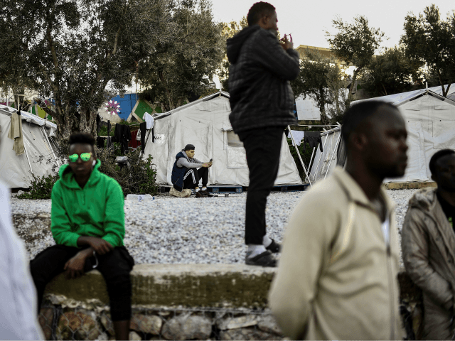 Men stand at an unofficial camp outside the refugee camp of Moria on the Greek island of L