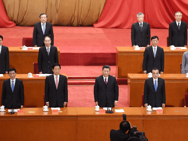 China's President Xi Jinping (C) and other leaders sing the national anthem at a ceremony