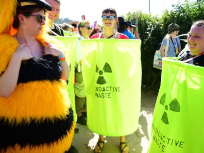 GLASTONBURY, ENGLAND - JUNE 27: Festival goers dressed as radioactive waste smile asthey t