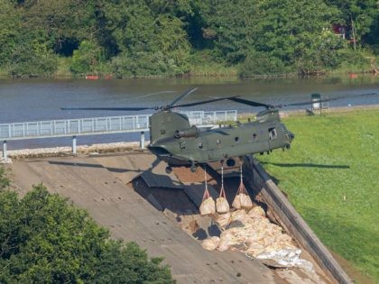 Personnel use a Royal Air Force (RAF) Chinook helicopter to lower bags of aggregate to reinforce the damaged spillway of the Toddbrook Reservoir dam above the town of Whaley Bridge in northern England on August 2, 2019. - Emergency services continued work to repair a damaged dam they fear could …