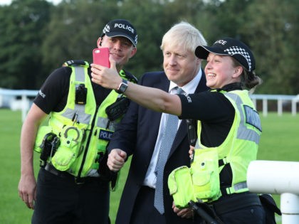 WHALEY BRIDGE, ENGLAND - AUGUST 02: Prime Minister Boris Johnson has a selfie with police officers as he arrives to meet emergency crews during a visit to Whaley Bridge Football Club as work continues at Toddbrook reservoir following a severe structural failure after heavy rain, on August 02, 2019 in …