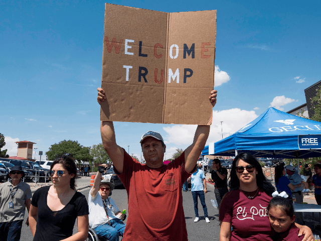A Trump supporter holds a sign outside the makeshift memorial to the victims of the WalMar