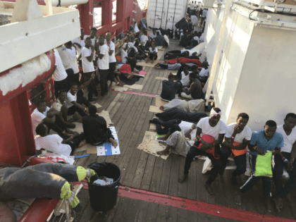 Rescued migrants rest on the desk of the 'Ocean Viking' rescue ship, operated by French NGOs SOS Mediterranee and Medecins sans Frontieres (MSF), during an operation in the Mediterranean Sea on August 12, 2019. - The rescue operation comes as a dispute escalates over which countries will take in migrants …
