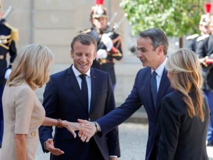 French President Emmanuel Macron (C-L) and his wife Brigitte Macron (L) welcome Greek Prime Minister Kyriakos Mitsotakis (C-R) and his partner Mareva Grabowski as they arrive for a meeting at the Elysee Palace in Paris on August 22, 2019. (Photo by GEOFFROY VAN DER HASSELT / AFP) (Photo credit should …