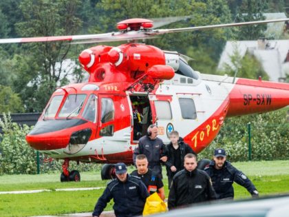 Polish rescue workers move injured tourists from a helicopter near Zakopane, Poland on Aug