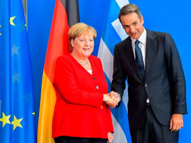 German Chancellor Angela Merkel(L)and Greek Prime Minister Kyriakos Mitsotakis(R)shake han