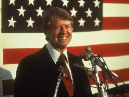 U.S. president Jimmy Carter smiling at a podium in front of an American flag, 1970s. (Photo by Hulton Archive/Getty Images)
