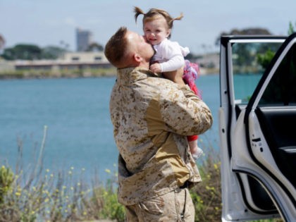 Gunnery Sgt. Michel Grabau hugs his daughter Mikaelie during a homecoming reception at Cam
