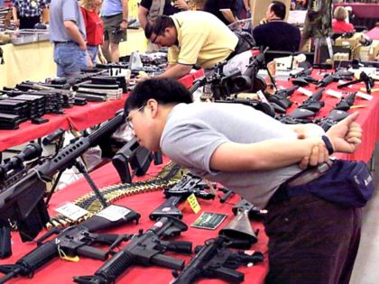 visitor to the Great Western Show checks out an assortment of assault rifles at the One-Eyed-Jacks, Inc., booth at the Las Vegas Convention Center 28 April 2000 in Las Vegas, Nevada. The show, which runs through 30 April 20000, recently moved to Las Vegas from California. AFP PHOTO/John GURZINSKI (credit: …