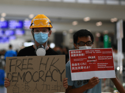 Pro-Democracy protesters gather against the controversial extradition bill at Hong Kong's international airport on August 11, 2019. - Empty hotel rooms, struggling shops and even disruption at Disneyland: months of protests in Hong Kong have taken a major toll on the city's economy, with no end in sight. (Photo by …