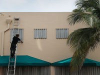 MIAMI BEACH, FLORIDA - AUGUST 30: Endre Eles places a hurricane shutter over a window as he helps prepare a business for the possible arrival of Hurricane Dorian on August 30, 2019 in Miami Beach, Florida. Dorian could be a Category 4 storm when it makes landfall Monday somewhere along …