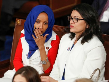 Rep. Ilhan Omar, D-Minn., left, joined at right by Rep. Rashida Tlaib, D-Mich., listens to President Donald Trump's State of the Union speech, at the Capitol in Washington, Tuesday, Feb. 5, 2019. (AP Photo/J. Scott Applewhite)