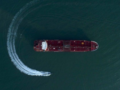 In this Sunday, July 21, 2019 photo, an aerial view shows a speedboat of Iran's Revolutionary Guard moving around the British-flagged oil tanker Stena Impero which was seized in the Strait of Hormuz on Friday by the Guard, in the Iranian port of Bandar Abbas. Global stock markets were subdued …