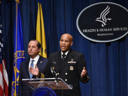 Surgeon General Jerome Adams (R) speaks watched by Health and Human Services Secretary Ale