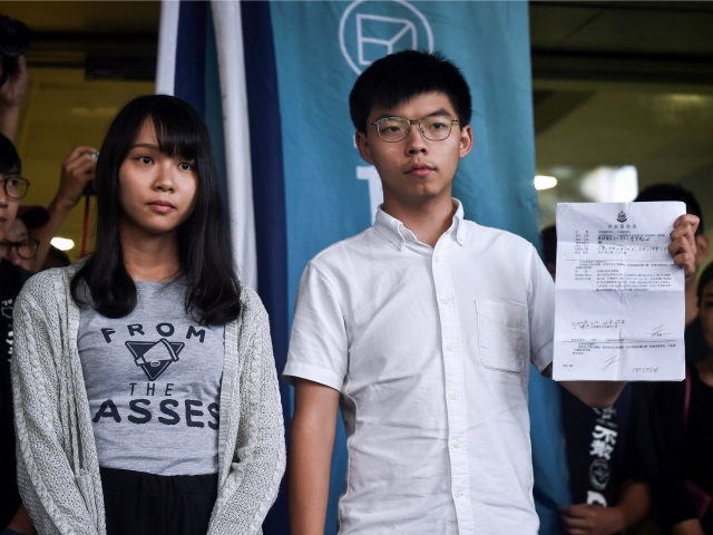 Pro-democracy activists Agnes Chow (L) and Joshua Wong (R) show the charges to the press after they were released on bail at the Eastern Magistrates Courts in Hong Kong on August 30, 2019. - Prominent democracy activists including a lawmaker were arrested on August 30 in a dragnet across Hong …