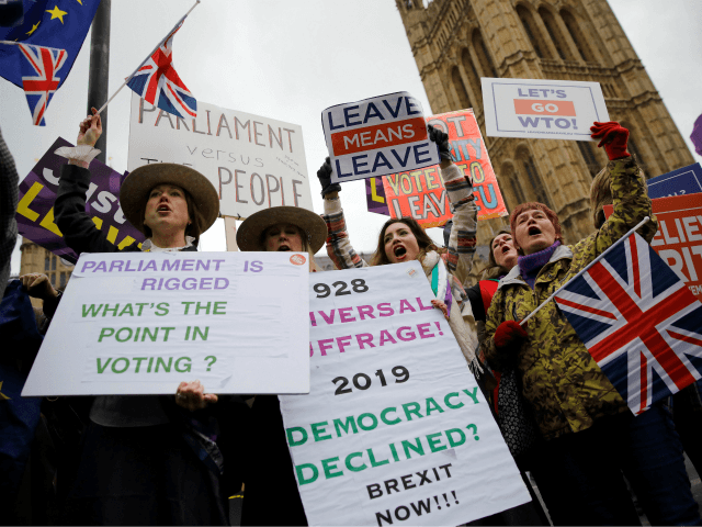 Pro-Brexit activists hold placards and wave Union flags as they demonstrate outside of the