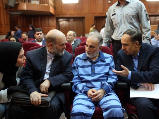 Former Tehran mayor Mohammad Ali Najafi (2nd-R), accused of shooting his second wife, speaks with his lawyer ahead of his trial at Iran's criminal court on July 13, 2019. - The high-profile trial opened today of a former Tehran mayor charged with murdering his wife, Iranian media reported. The charge …