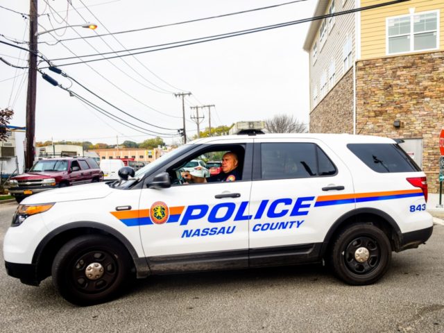 A Nassau County Police officer sits in front of a crime scene at 130 Secatogue Ave. Octobe