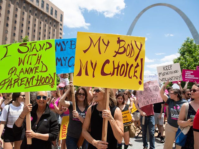 Protesters hold signs as they rally in support of Planned Parenthood and pro-choice and to protest a state decision that would effectively halt abortions by revoking the center's license to perform the procedure, near the Gateway Arch in St. Louis, Missouri, May 30, 2019. (Photo by SAUL LOEB / AFP) (Photo credit should read SAUL LOEB/AFP/Getty Images)