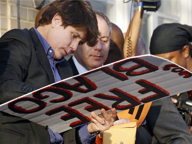 This March 14, 2012 file photo shows former Illinois Gov. Rod Blagojevich autographing a 'Free Gov. Blago' sign for one of his supporters at his home in Chicago the day before Blagojevich was due to report to prison to begin serving a 14-year sentence on corruption charges. Blagojevich's lawyers submitted …