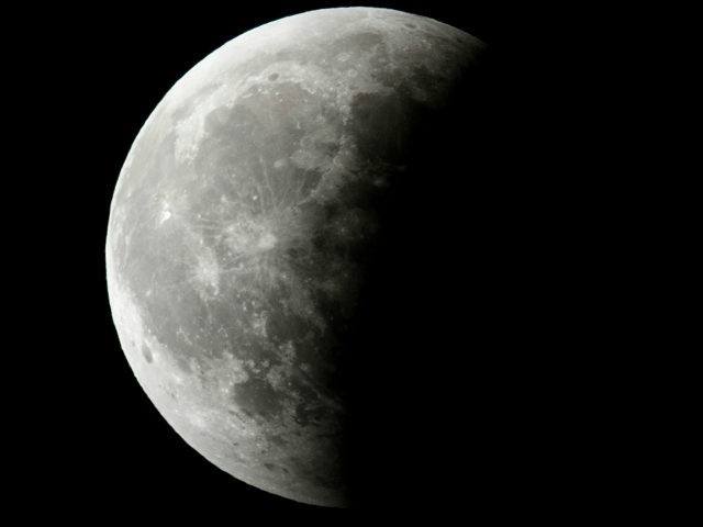 Earth's shadow moves across the Super Blood Wolf Moon during a total lunar eclipse on Janu