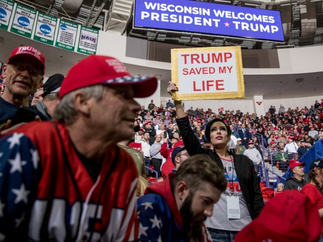 A woman in the audience holds a sign that reads "Trump Saved My Life" as she waits for President Donald Trump to take the stage at a rally at Resch Center Complex in Green Bay, Wis., Saturday, April 27, 2019. (AP Photo/Andrew Harnik)
