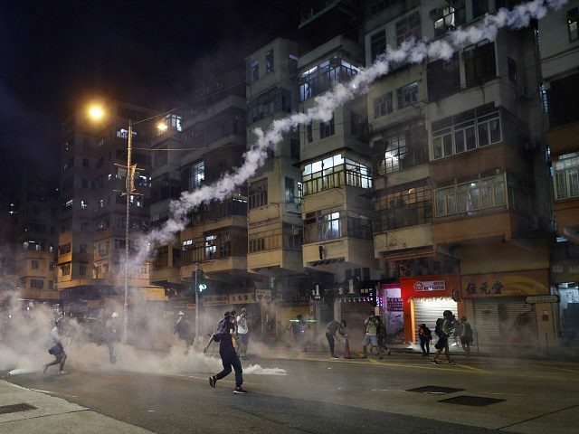 Protesters react to tear gas from Shum Shui Po police station in Hong Kong on Wednesday, A