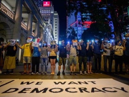 People hold hands and use their phone torches as they form a human chain in Hong Kong on August 23, 2019. - The protest in Hong Kong coincided with the 30th anniversary of the Baltic Way demonstration in 1989, which saw about 2 million people form a human chain that …