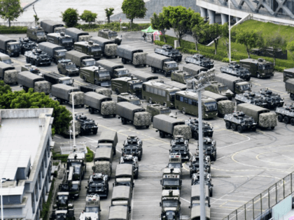 This Friday, Aug. 16, 2019, photo shows armored vehicles and troop trucks are parked outsi