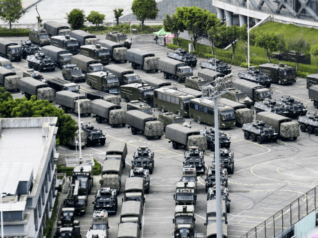 This Friday, Aug. 16, 2019, photo shows armored vehicles and troop trucks are parked outside Shenzhen Bay Stadium in Shenzhen, China. Members of China's paramilitary People's Armed Police marched and practiced crowd control tactics at a sports complex in Shenzhen across from Hong Kong on Friday, in what some interpreted …